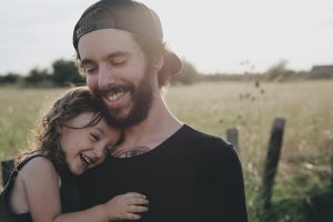un père porte sa fille dans les bras pour faire un test de paternité