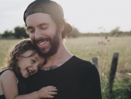un père porte sa fille dans les bras pour faire un test de paternité