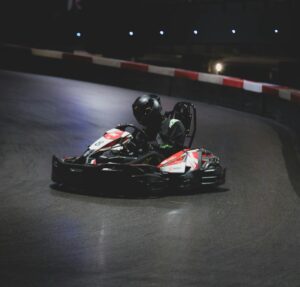 Une course de karting palpitante sur une piste intérieure sous les lumières de la nuit.