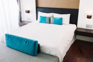 Gros plan sur un lit avec des oreillers bleus, mettant en avant un lit 160x200 cm pour un confort et un style optimaux
