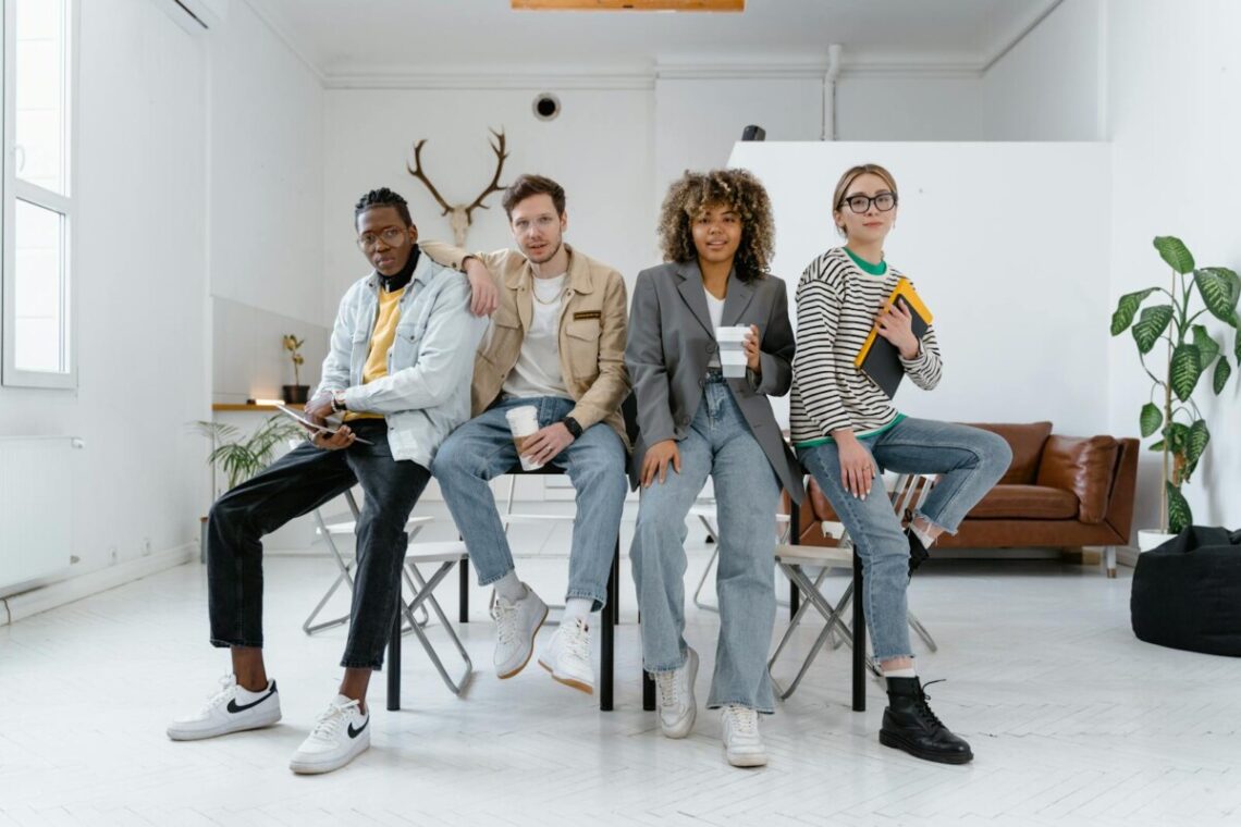 Un groupe multiculturel de jeunes professionnels dans un environnement de bureau moderne, mettant en valeur le travail d'équipe et la créativité.
