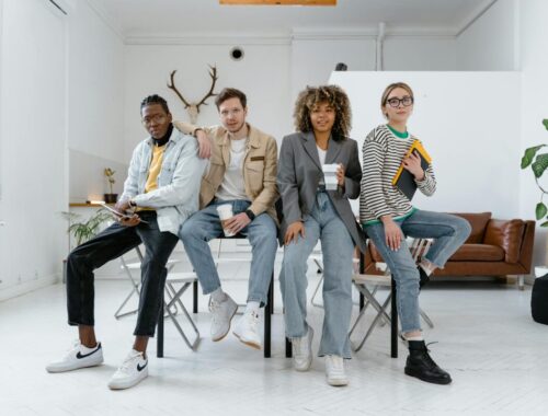 Un groupe multiculturel de jeunes professionnels dans un environnement de bureau moderne, mettant en valeur le travail d'équipe et la créativité.