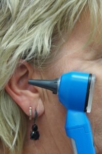 Un médecin utilise un otoscope pour vérifier l’oreille.