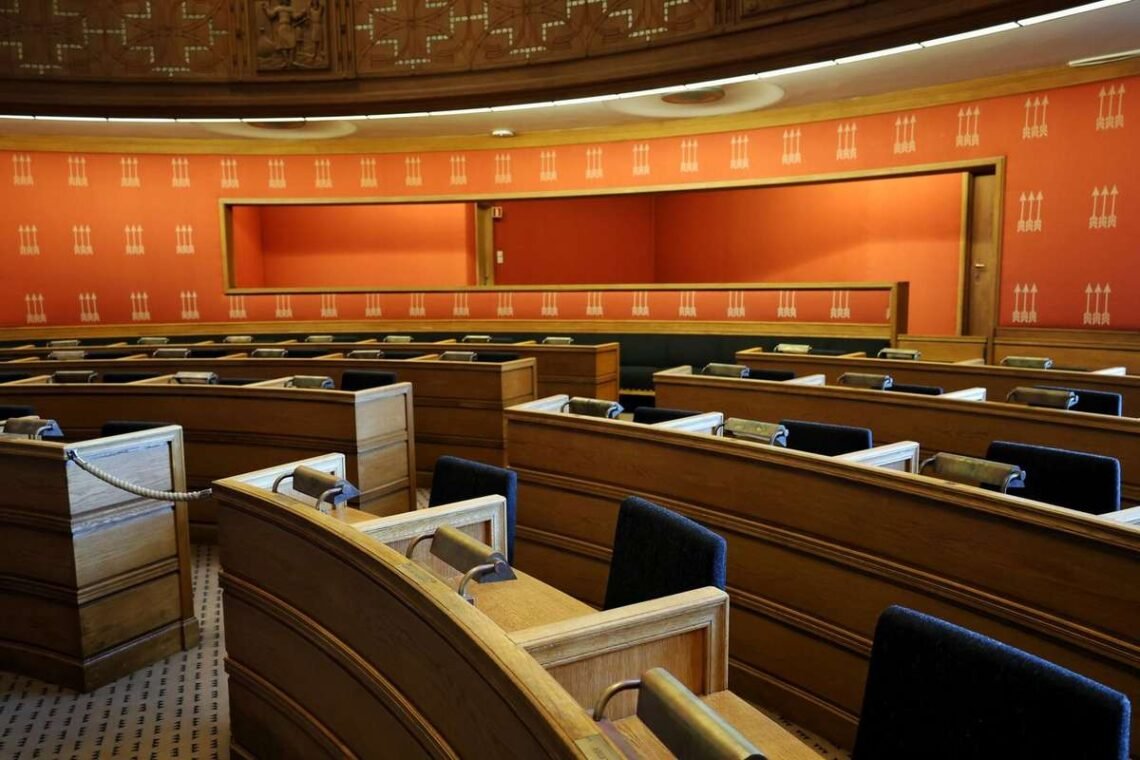 Salle de réunion avec bureaux courbes, chaises noires et murs oranges