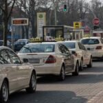 Une file de taxis et voitures attend au feu vert sur la rue