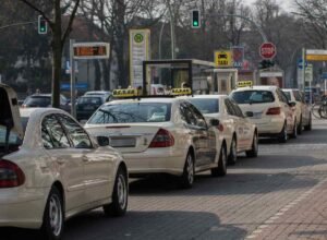 Une file de taxis et voitures attend au feu vert sur la rue
