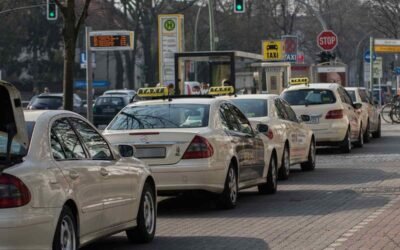 Une file de taxis et voitures attend au feu vert sur la rue
