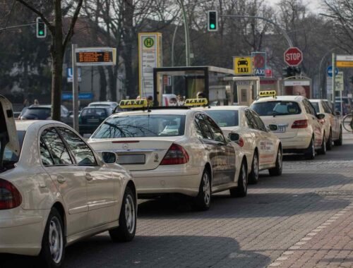 Une file de taxis et voitures attend au feu vert sur la rue