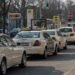 Une file de taxis et voitures attend au feu vert sur la rue