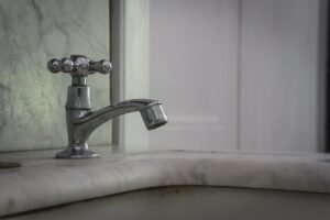 Un robinet à poignée croisée sur un lavabo en marbre