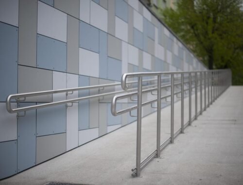 Un rampant avec main-courante métallique et mur céramique bleu blanc