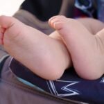 Pieds d'enfant sur un siège de poussette avec motif de couronne