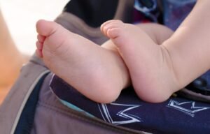 Pieds d'enfant sur un siège de poussette avec motif de couronne