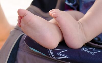 Pieds d'enfant sur un siège de poussette avec motif de couronne