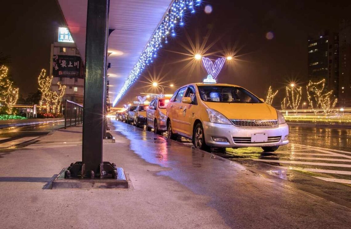 Des taxis jaunes attendent sous un pont décoré de lumières