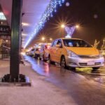 Des taxis jaunes attendent sous un pont décoré de lumières