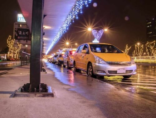 Des taxis jaunes attendent sous un pont décoré de lumières