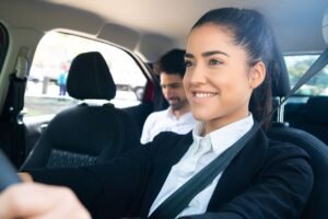 Une femme souriante conduit une voiture avec un passager à l'arrière