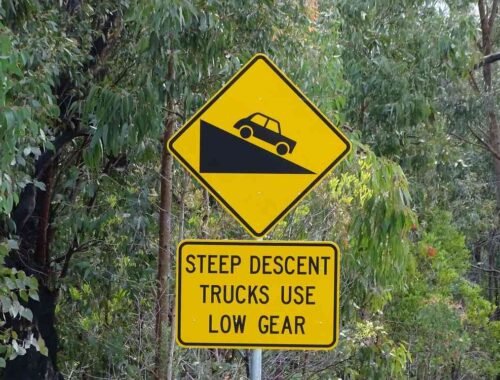 Panneau jaune indiquant une descente pour camions, avec véhicule