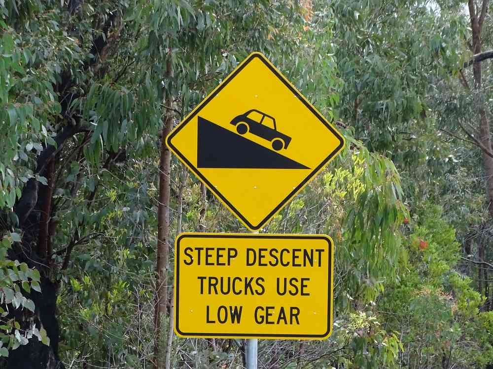 Panneau jaune indiquant une descente pour camions, avec véhicule