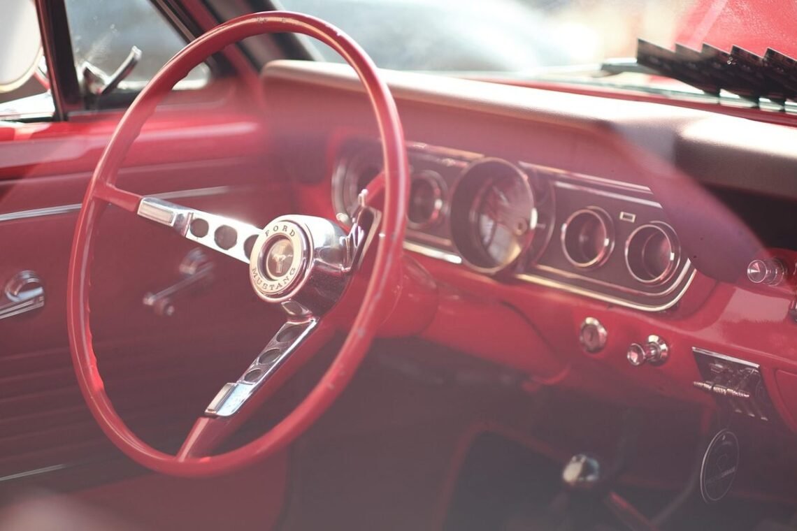 Intérieur d'une voiture vintage rouge avec volant et tableau de bord