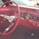 Intérieur d'une voiture vintage rouge avec volant et tableau de bord