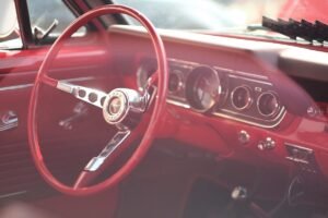 Intérieur d'une voiture vintage rouge avec volant et tableau de bord