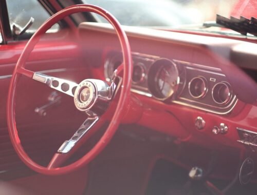 Intérieur d'une voiture vintage rouge avec volant et tableau de bord