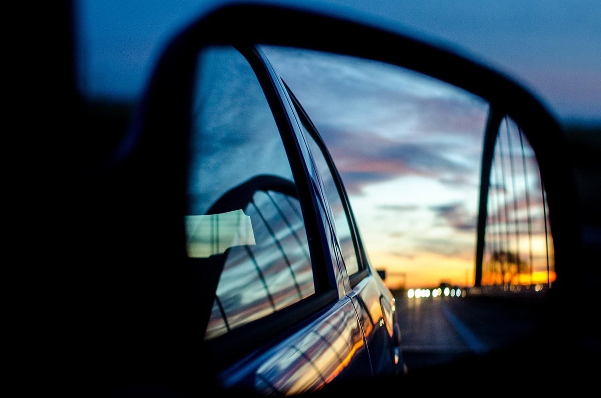 Reflet du crépuscule dans le miroir latéral d'une voiture