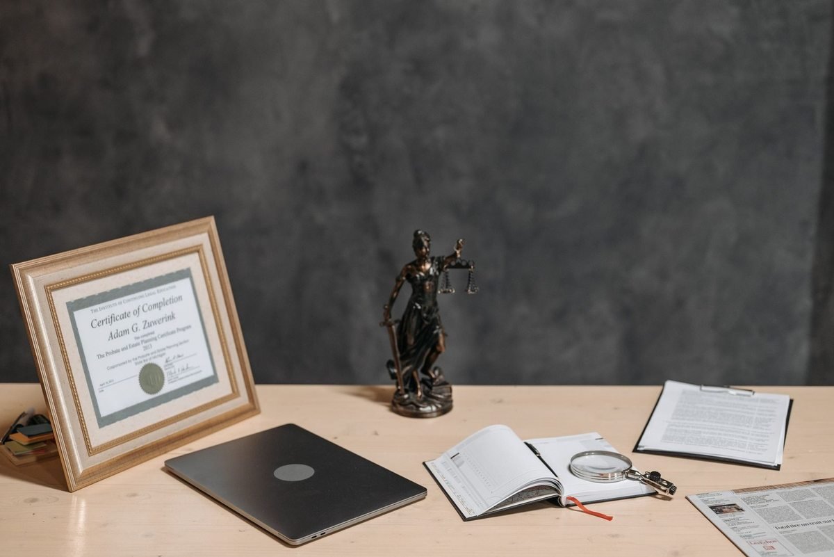 Bureau avec certificat, statue de justice, livre ouvert et documents