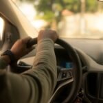 Un conducteur tient le volant à l'intérieur d'une voiture