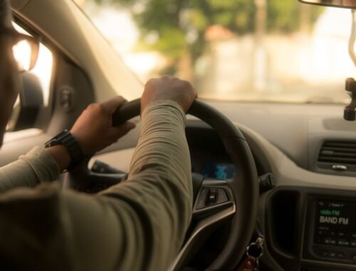 Un conducteur tient le volant à l'intérieur d'une voiture