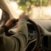 Un conducteur tient le volant à l'intérieur d'une voiture