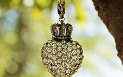 Un pendentif cœur en pierres orné d'une couronne suspendu à une chaîne