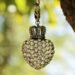 Un pendentif cœur en pierres orné d'une couronne suspendu à une chaîne
