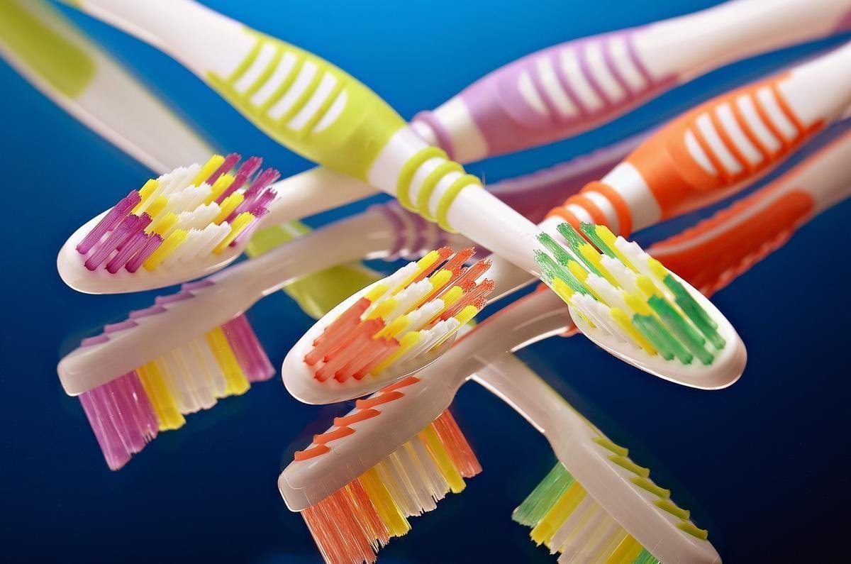 Brosses à dents colorées disposées en diagonale sur fond bleu