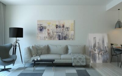 Un salon clair avec canapé, chaise, tableau, lampes et table basse