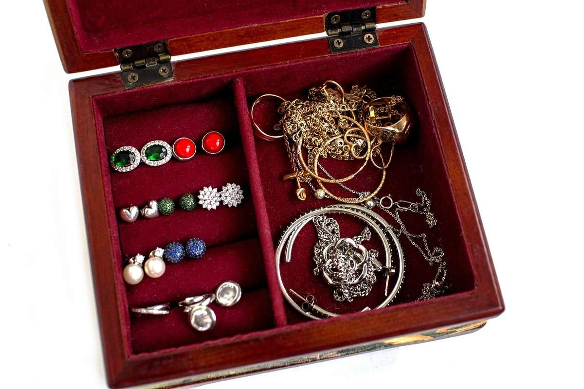 ALT: Boîte à bijoux en bois ouverte avec bagues, colliers, boucles d'oreilles et bracelets