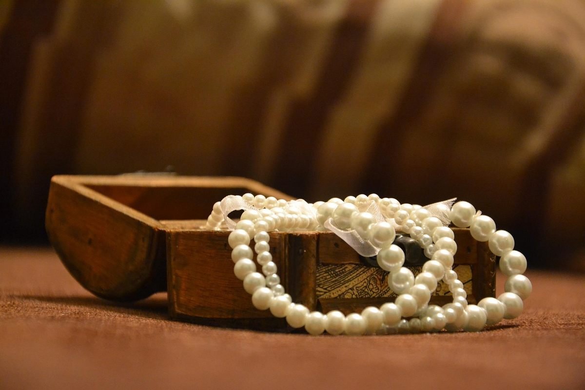 Des mains tenant un collier pour en inspecter le fermoir.