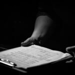 Des mains tiennent un classeur avec une feuille de papier