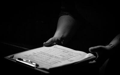 Des mains tiennent un classeur avec une feuille de papier