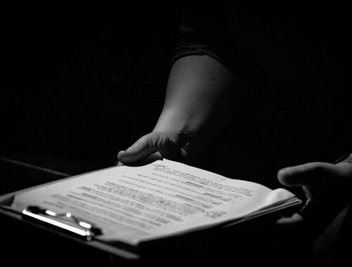 Des mains tiennent un classeur avec une feuille de papier
