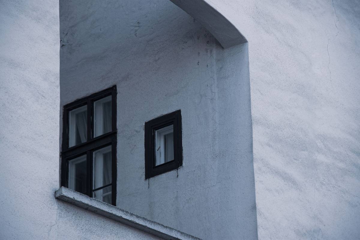 deux fenêtres noires sur façade blanche, aucune activité visible