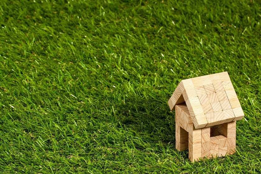 Maison en bois miniature sur gazon synthétique Maison en bois miniature sur gazon synthétique