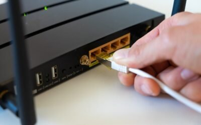une main branche un câble Ethernet dans un routeur noir